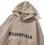 Beige unisex Essentials hoodie with soft fabric, long sleeves, and a cozy pullover design.